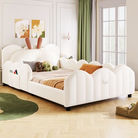 Lit pliant recouvert de duveteux matériaux, avec un oreiller en forme de lapin. Couleur beige. (1/5)