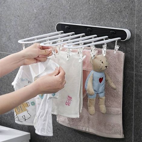 Étendoir à linge mural pliable avec crochets, facile à installer et stable.