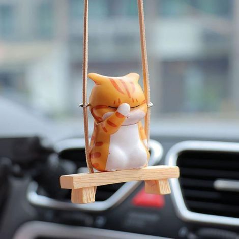 Un chat se cache le visage sur une balançoire un pendentif décoratif en plastique pour voiture. (1/5)