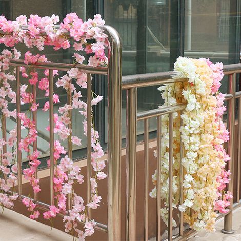Une vigne artificielle de cerisier de 1,8 mètre de long, composée de 135 fleurs, enroulée autour d'une gaine de climatisation une vigne de fleurs artificielles blanches à usage décoratif. (1/5)