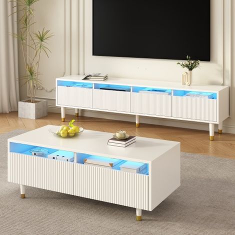Cette table basse moderne à LED est dotée d'un plateau à tiroirs ondulé, de pieds dorés et blancs, de deux tiroirs et de bandes lumineuses LED à couleurs changeantes. Un meuble TV assorti est égalemen