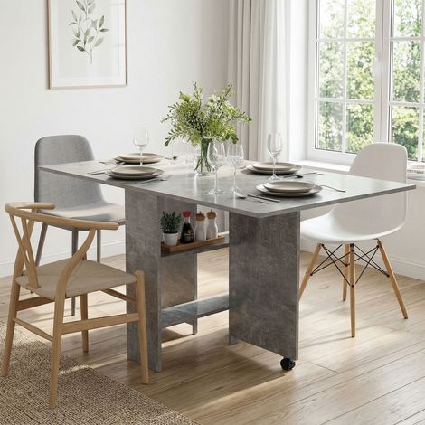 Mesa de comedor plegable con estantes, tablero abatible y ruedas, color gris cemento.