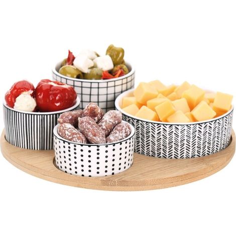Cuatro tazones de porcelana sobre una bandeja de bambú para servir delicias