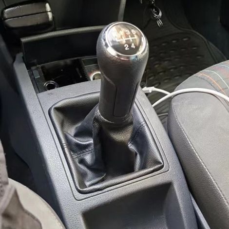 Dieses Set beinhaltet eine Staubschutzhülle für den Schaltknauf eines Volkswagen Polo, einen Lederknauf mit roten Ziernähten und schwarzer Umrandung sowie ein Getriebe (1/4)