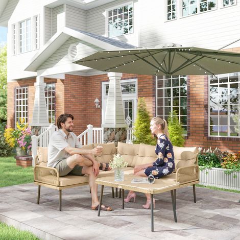 Ensemble de jardin en rotin avec 2 canapés et un fauteuil d'angle avec coussins. Table basse en verre. Couleur bois.