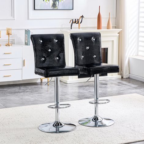Deux chaises de bar vintage en cuir de crocodile noir, avec fermoir en cristal et revêtement en similicuir, ajoutent une touche d'élégance et de mystère à la salle à manger. (1/5)