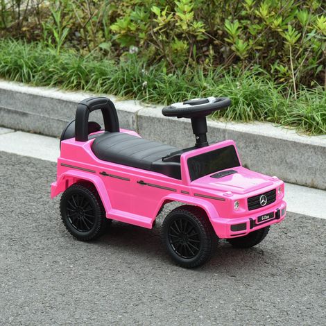 Ein lizenzierter Mercedes-Benz Kinder-Elektro-LKW für Kinder von 12 bis 36 Monaten. Ausgestattet mit Kofferraum, Hupe, Scheinwerfern und rosa Zierelementen. (1/5)
