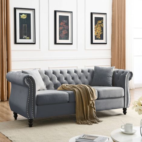 Canapé 3 places Chesterfield en velours – Boutons capitonnés et clous argentés – Dossier bas et coussins amovibles – Pieds en bois d’hévéa – Gris