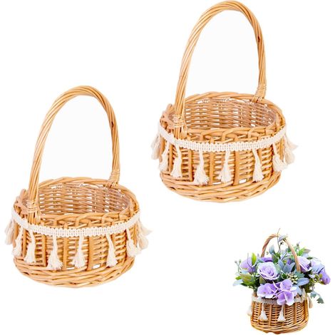 Deux paniers à fleurs tressés avec pompons, un panier de mariage, un panier en osier avec anses et un panier à fleurs en rotin tressé pour la décoration de table lors d'un mariage. (1/3)