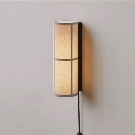 Una lámpara de pared metálica ligera, apta para uso en interiores, con el enchufe y el interruptor situados junto a la cama y una tela de estilo vintage. (1/5)