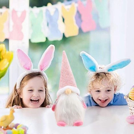 Tischdekoration fürs Wohnzimmer: ein cartoonartiger Osterhase, eine niedliche, gesichtslose Puppe. (1/4)