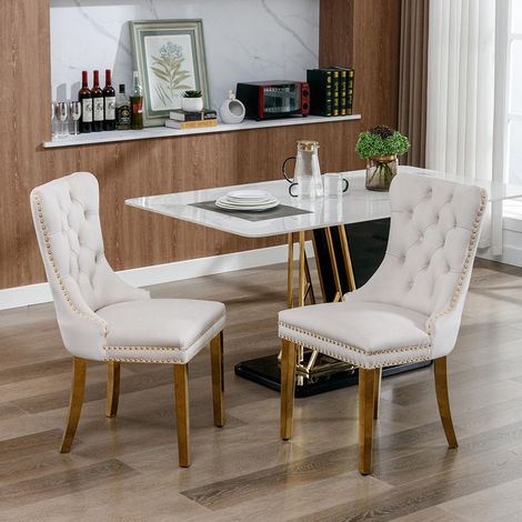 Chaise de salle à manger rembourrée avec pieds en acier inoxydable plaqué or, garniture à clous, revêtement en velours, couleur beige-or. (1/5)