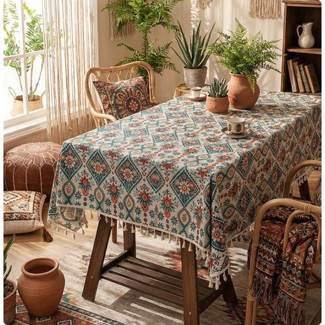 Nappe rectangulaire imprimée d'un motif losanges et ornée de pompons colorés. Dimensions : 140 x 100 cm. (1/5)