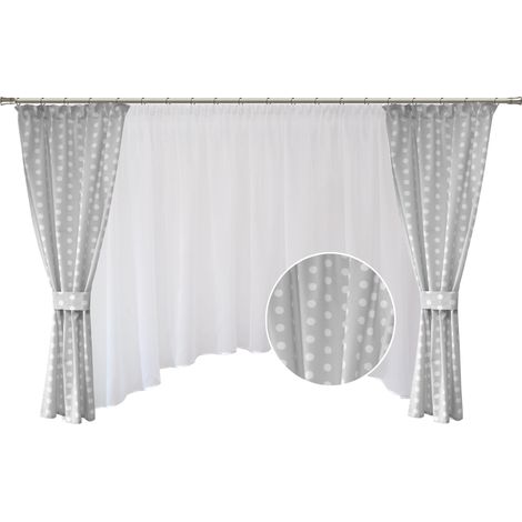 Set di tende e drappeggi grigi a pois per una cameretta da bambina in stile bohémien.