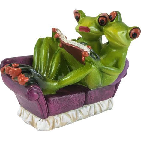 Figurine de grenouille sur le canapé avec un livre (1/5)