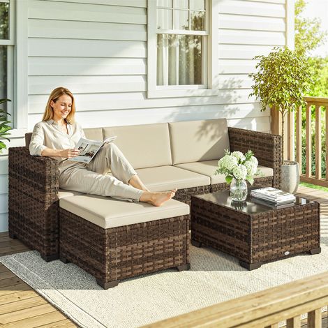 Set da giardino in rattan composto da 5 pezzi con cuscini, 2 poltrone angolari, sedia senza braccioli, poggiapiedi e tavolo.
