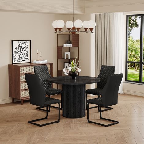 Ensemble table et chaises: table à manger ronde en MDF de 100 cm, plateau noir, pieds cylindriques et système auto-agrippant, avec 4 chaises de salle à manger noires à motif losange sur le dossier.