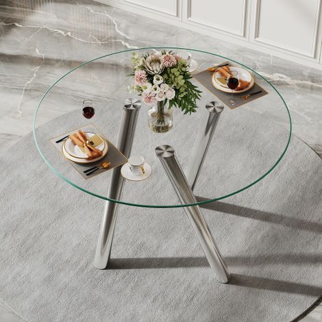 Tavolo da pranzo rotondo da 89 cm, realizzato in vetro temperato con robuste gambe in metallo argentato.