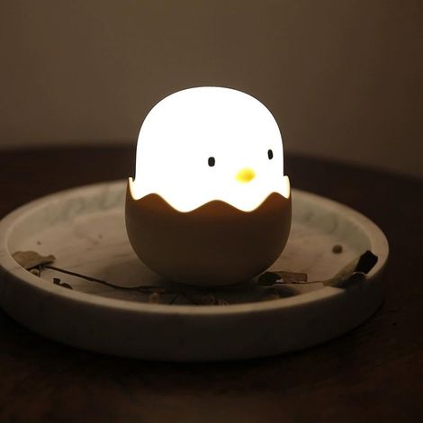 Pequeña luz nocturna blanca con forma de cáscara de huevo y un pollito para acariciar. (1/2)