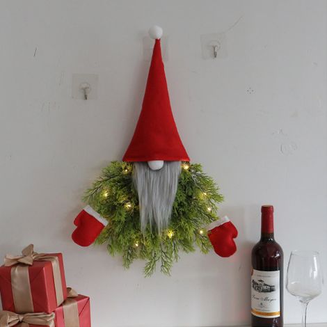 Beleuchteter Weihnachtskranz mit der Darstellung eines gesichtslosen alten Mannes zum Aufhängen an einer Tür in einem Restaurant oder einer Bar. Weihnachtsdekoration für ein Restaurant oder eine Bar. (1/5)