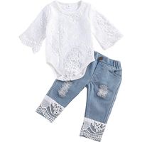 Ensemble de vêtements pour bébé fille : barboteuse, haut et jean.