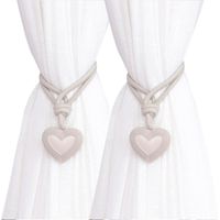 Set of braided rope tiebacks with heart-shaped pendants for elegant window decoration.
