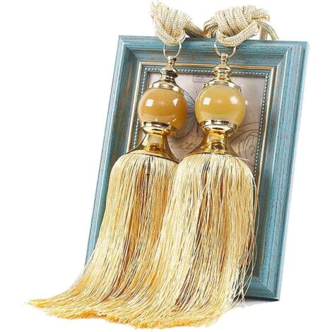 Zwei Bänder mit Pompons, handgebundene Pompons, goldene Dekoration für Zuhause.